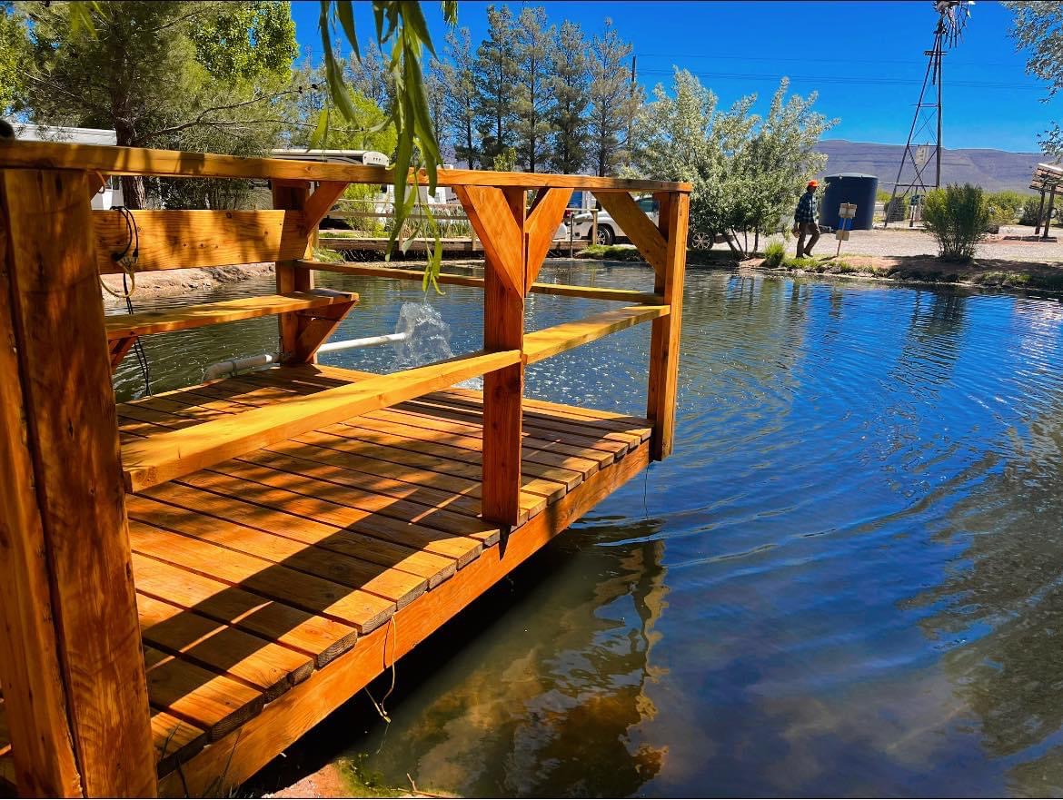 Beautiful cedar fishing dock over the crystal-clear pond at Edgington RV Park