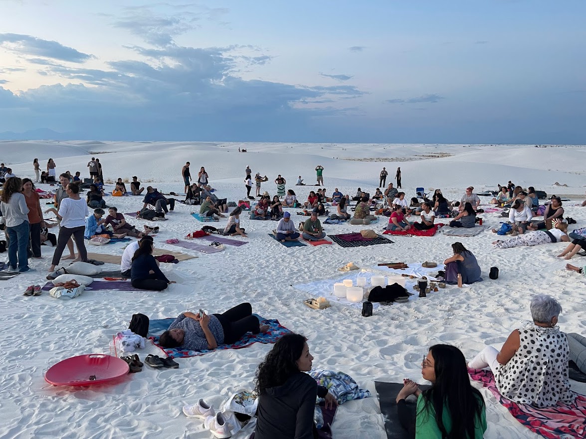 White Sands National Park — people relaxing on the white sand dunes at sunset